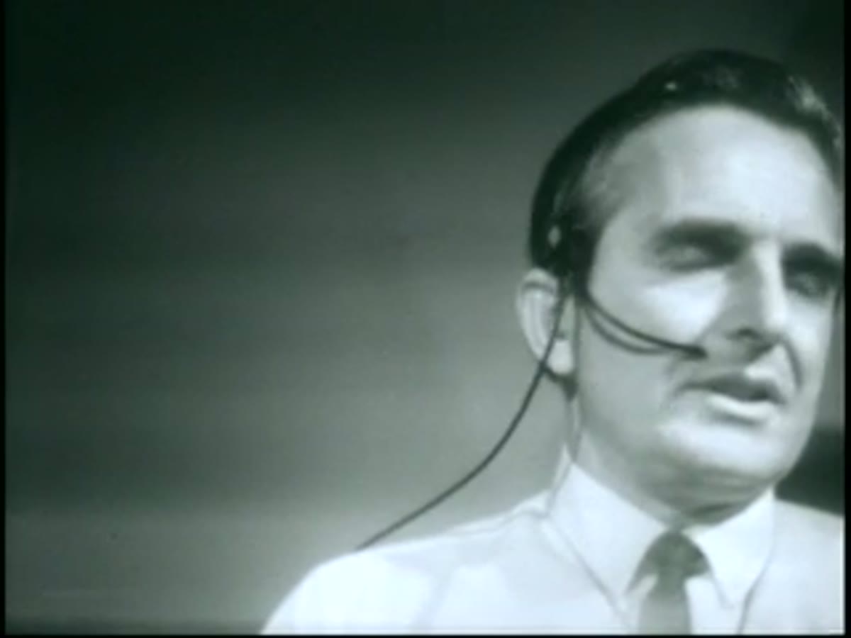 Douglas Engelbart, wearing a headset microphone, mid-presentation during the 1968 demo.
